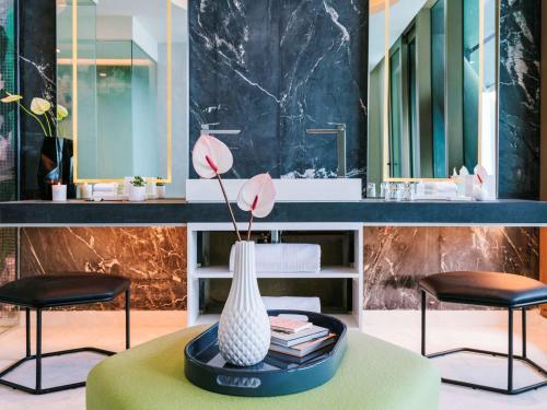 a bathroom with a table with a vase and two chairs at Sofitel Mexico City Reforma in Mexico City