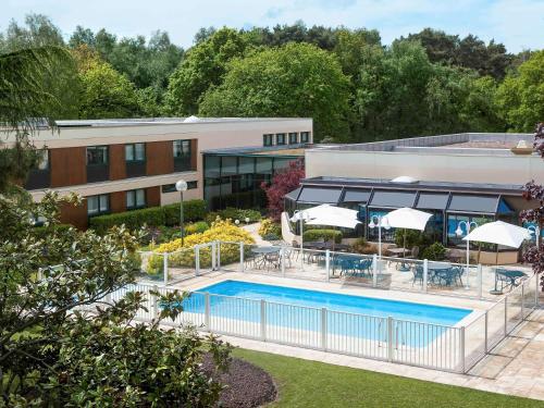 un hotel con piscina frente a un edificio en Novotel Rouen Sud en Saint-Étienne-du-Rouvray