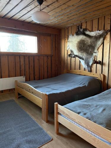 A bed or beds in a room at Riihitulkku Lodge