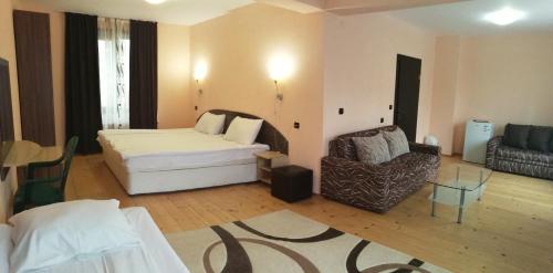 a hotel room with a bed and a chair at Apartments Black Horse in Pamporovo