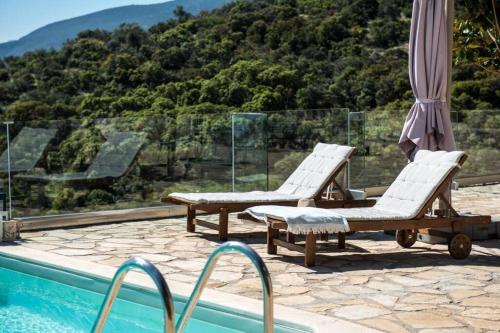 a swimming pool with two lounge chairs and a swimming pool at Apollo Romantic Sea View Villa in Kivérion