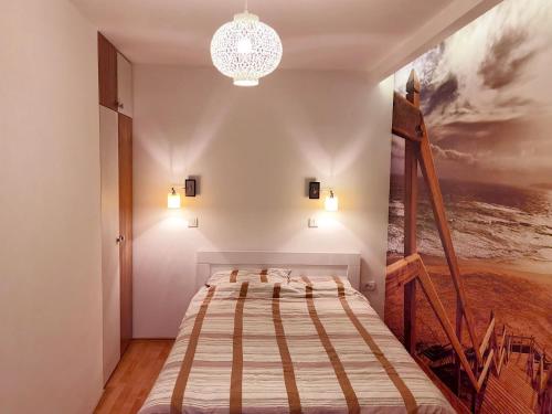 a bedroom with a bed and a painting on the wall at Alo Alo Apartman 6 in Kruševac