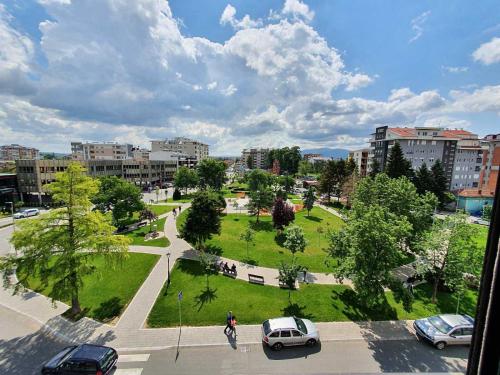 - une vue sur un parc avec des voitures garées dans une ville dans l'établissement Alo Alo Apartman 6, à Kruševac