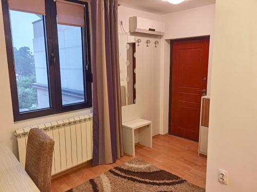 Habitación con ventana grande y puerta. en Alo Alo Apartman 6, en Kruševac