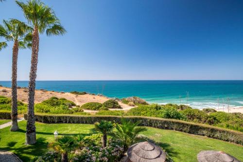 a view of the beach from a resort with palm trees at Clube Porto Mos - Sunplace Hotels & Beach Resort in Lagos