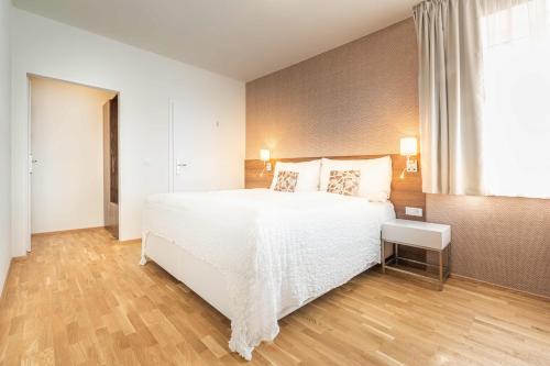 a bedroom with a large white bed and a window at Vila EVA in Luhačovice