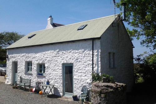 a small white stone building with a roof at The Dairy @ Mill Haven Place in Haverfordwest