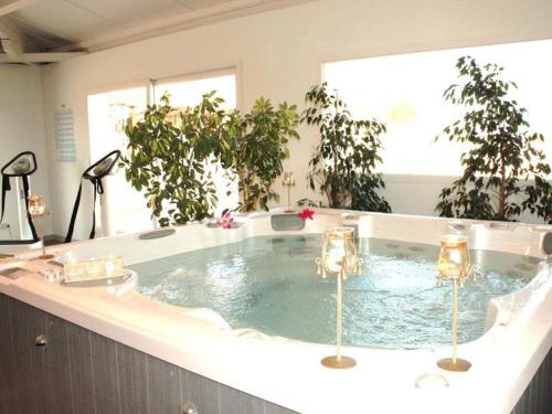 une baignoire jacuzzi dans une chambre avec des plantes en pot dans l'établissement SABLE DU MIDI chez gégé, à Valras-Plage