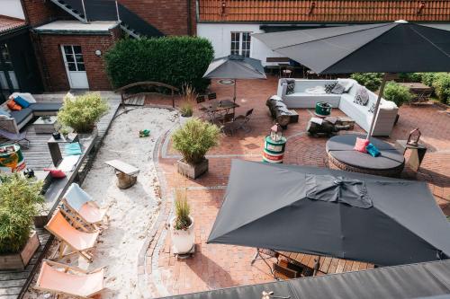 an aerial view of an outdoor patio with umbrellas at Krögers Hotel in Esens