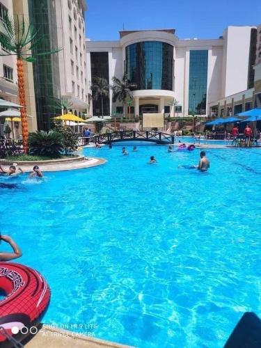 a group of people swimming in a large swimming pool at Paradise Home City Stars in Cairo