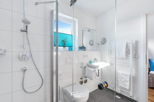 een badkamer met een douche, een toilet en een wastafel bij Blaue Lagune in Olpenitz