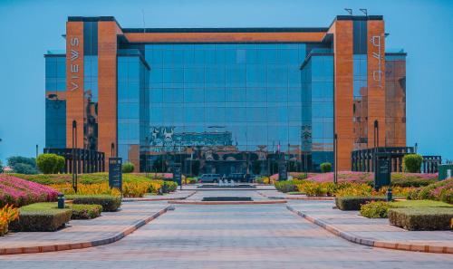 a large glass building with a walkway in front of it at Views Hotel & Residences in King Abdullah Economic City