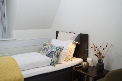 a room with a bed with pillows and a table at Skarrildhus Sinatur Hotel & Konference in Skarrild