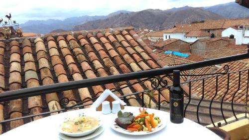 a table with a plate of food on a balcony at Hotel & Mirador Los Apus in Cusco