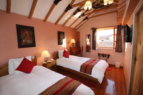 a hotel room with two beds and a window at Hotel & Mirador Los Apus in Cusco