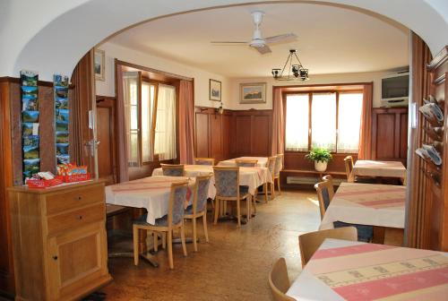 un ristorante con tavoli e sedie in una stanza di Pensione Capelli a Prada