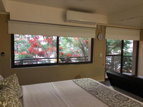 a bedroom with a bed and two windows and a clock at Perito Moreno - 3ro C in Puerto Iguazú