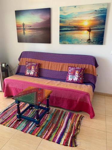 Puerto de las LajasにあるFuertelena Sunrise Lovers Apartmentのベッドルーム1室(ベッド1台、ラグの上にテーブル付)