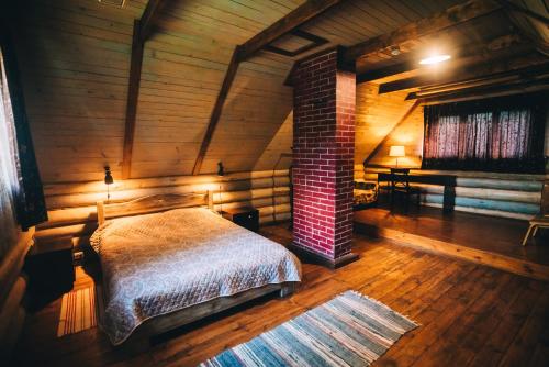 1 dormitorio con 1 cama en una habitación de madera en Vysokoe Club Hotel, en Vysokoye