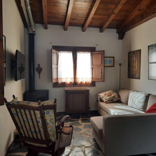 een woonkamer met een bank en een raam bij Palacio Viejo de Las Corchuelas in Torrejón el Rubio