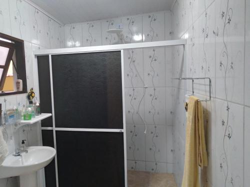 y baño con ducha y lavamanos. en Studio Tipo Chale PRAIA SANTA TEREZA, en Ilhabela