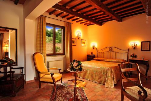 1 dormitorio con 1 cama, mesa y sillas en Hotel La Fonte Del Cerro en Saturnia