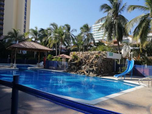 uma piscina num resort com palmeiras em Casa, playa Bello Horizonte Santa Marta Colombia em Santa Marta