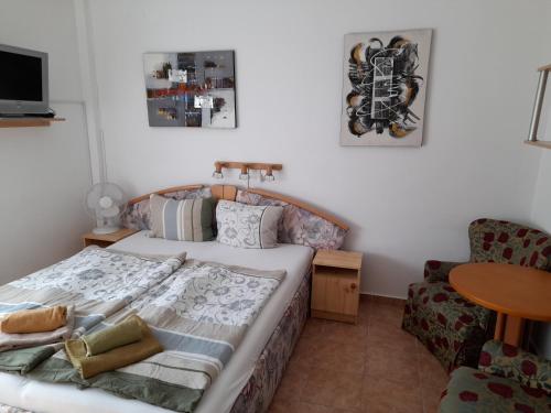 ein Schlafzimmer mit einem Bett, einem Stuhl und einem Tisch in der Unterkunft Guest House Móritz in Keszthely