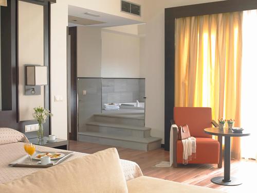 ein Wohnzimmer mit einem Sofa und einem Tisch in der Unterkunft Hotel Isla de La Garena in Alcalá de Henares