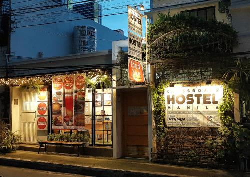 a store with signs on the side of a street at Crossroads Hostel Manila in Manila