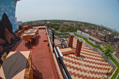 a building with tables and chairs on a roof at Paramount Tower in Kozhikode