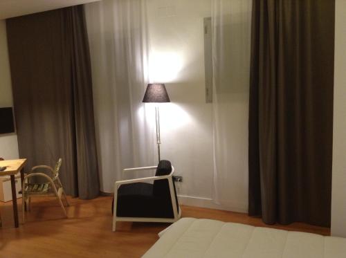 a room with a tv and a lamp in a room at Las Coles Apartasuites in Xàtiva