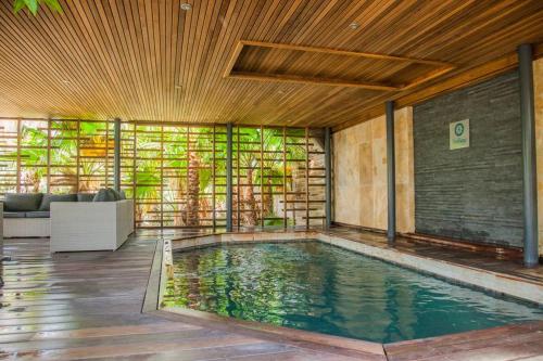 uma piscina numa casa com uma parede de vidro em Holidays by juliano camping 5 etoiles 3149 em Grimaud