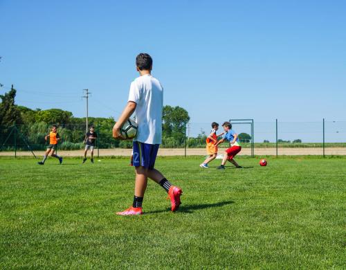 a group of young people playing soccer on a field at Luxury Camp at Union Lido in Cavallino-Treporti