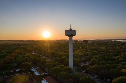 a control tower with the sunset in the background at Luxury Camp at Union Lido in Cavallino-Treporti