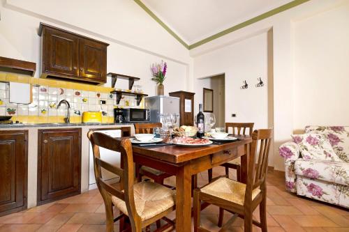 a kitchen with a wooden table and chairs in a room at Borgo Grondaie in Siena