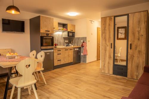 a kitchen with wooden floors and a table and chairs at Apartmány Kůlna in Boží Dar