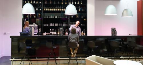 a man standing at a bar with a woman at Mercure Cholet Centre in Cholet