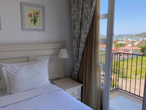 - une chambre avec un lit et un balcon avec vue dans l'établissement IL CAMPANARIO JURERE INTERNACIONAL FLORIANÓPOLIS, à Florianópolis