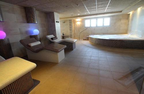 a large bathroom with a large tub and a bath room at Hotel Peñiscola Palace in Peñíscola