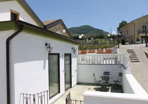 a white house with a balcony with a table and chairs at Locanda Arcadia in Picerno