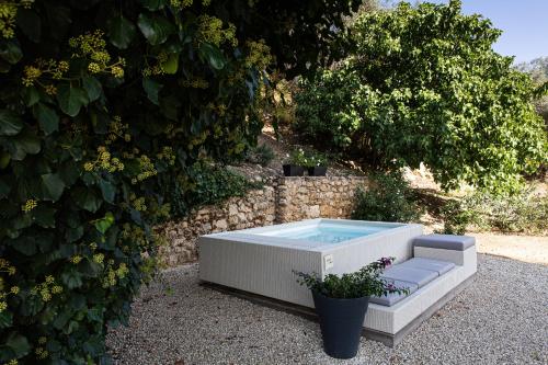 a hot tub sitting on the ground next to a bush at La Casa del Poeta Enna - Pergusa in Enna