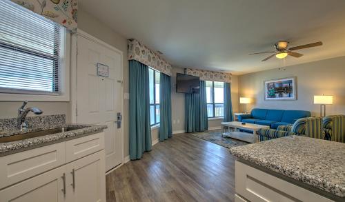 a kitchen and living room with a blue couch at Atlantic Beach Resort, a Ramada by Wyndham in Atlantic Beach
