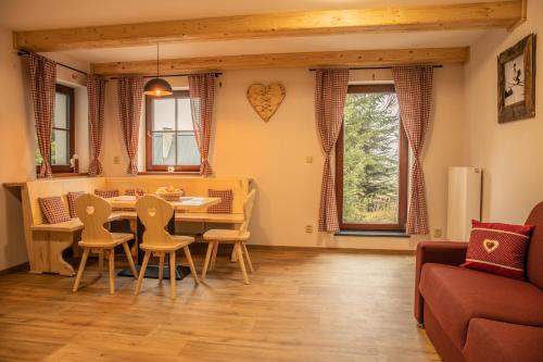 ein Wohnzimmer mit einem Tisch und Stühlen in der Unterkunft Apartmány Kůlna in Boží Dar