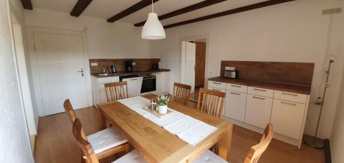 a dining room with a wooden table and chairs at Ferienwohnungen Hafnerkarl in Falkenberg