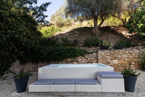 a white couch sitting next to a stone wall at La Casa del Poeta Enna - Pergusa in Enna