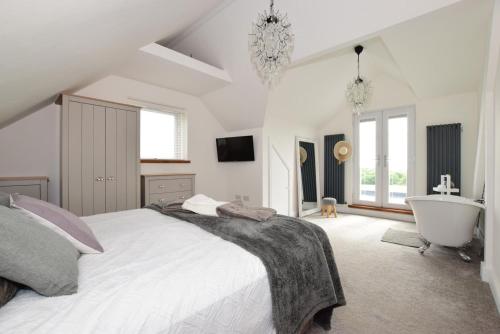 a bedroom with a large bed and a bath tub at Corbiere in Shanklin
