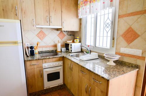 a small kitchen with a sink and a refrigerator at Casa Manoli in Conil de la Frontera