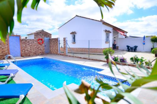 a swimming pool in front of a house at Casa Manoli in Conil de la Frontera