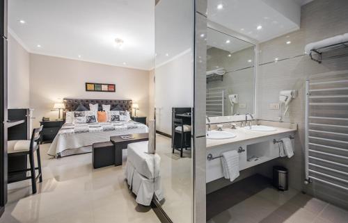 a bathroom with a bed and a sink and a mirror at Hotel Nuevo Ostende by bund in Mar del Plata
